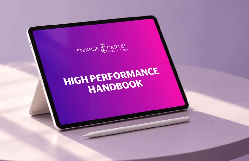 Tablet on a stand showing the Fitness Cartel High Performance Handbook cover in pink and purple